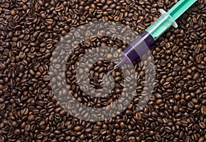 Syringe with poisonous liquid on coffee beans