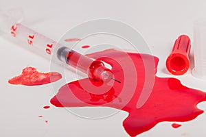 Syringe Squirting Red Blood onto White Background