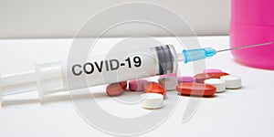 Syringe and tablets of various color antivirus protection photo