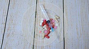 Syringe and tablets of various color antivirus protection on white background photo