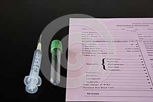 A syringe, testtube, and laboratory request