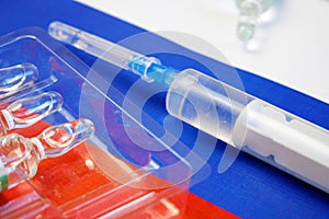 Syringe with a vaccine  on background of the Russian Federation flag, vaccine against coronavirus