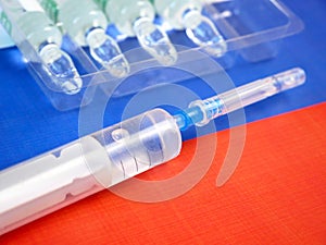 Syringe with a vaccine  on background of the Russian Federation flag, vaccine against coronavirus