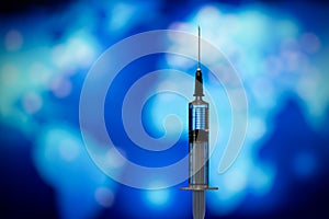 Syringe with vaccine on blue background