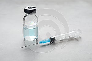 Syringe and vial on grey table. Medical anesthesia