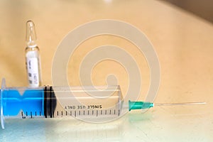 Syringe and a vial with medication on table close