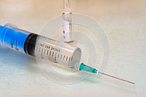 Syringe and a vial with medication on table close