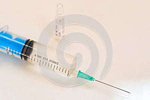 Syringe and a vial with medication on table close