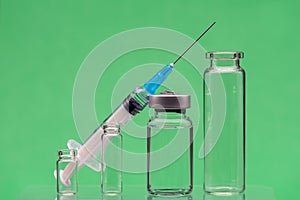 syringe and vials on a green background