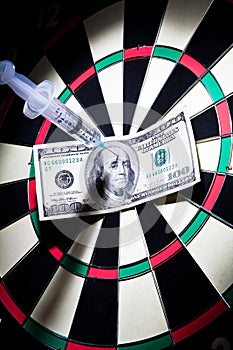 Syringes and money stuck on a dartboard