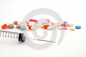 Syringes and tablets on white background