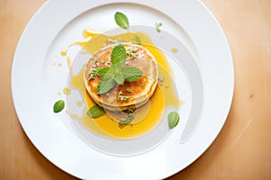 syrup-glossed pancakes with a sprig of mint