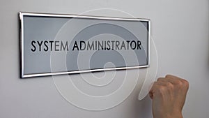 System administrator office door, hand knocking closeup, computer specialist