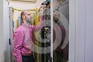 The system administrator works in the server room. The network engineer switches the wires in the data center. A young man is