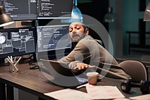 IT system engineer coding database on multiple monitors