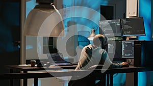 IT system engineer coding interface on multiple monitors