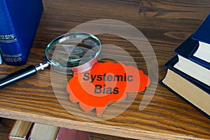 Systematic bias concept. Sign and magnifying glass on the shelf. photo