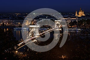 Szechenyi chain bridge budapest, lit up at night time, with St. Stephen`s Basilica