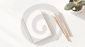 White spiral notebook with blank pages placed on a white surface.