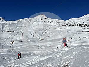 T-bar ski lift (Schlepplift mit T-BÃ¼gel-Anker) on the snowy slopes of the Swiss alpine winter resort of Arosa