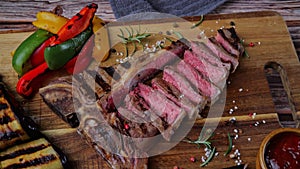 T- bone beef steak grilled sliced with grilled vegetables rotate wooden cutting board