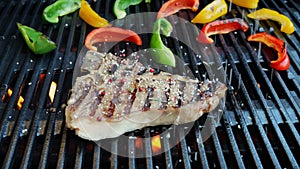 T- bone steak grill with vegetables on a cast iron barbecue sprinkle with spices. Slow motion