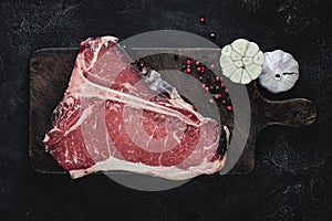 T-bone Steak Raw Dry Aged Beef on Vintage Cutting Board