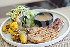 T Bone steak with sauce, Potato and fresh vegetable.