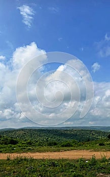 TÃ¼rkiye. Valley of trees with a path against a blue sky with clouds. photo