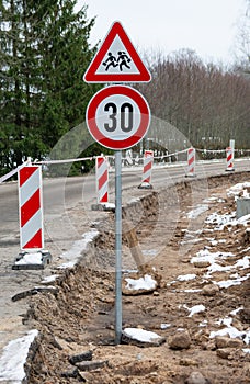 T road repair works and speed limit sign.