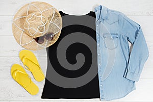 T shirt black and slippers. T-shirt Mockup flat lay with summer accessories. Hat, yellow flip flops and sunglasses on wooden floor