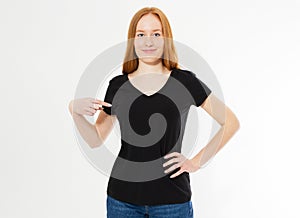 T-shirt design, happy people concept - smiling red hair woman in blank black t-shirt pointing her fingers at herself, red head