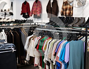T-shirts and blouses hanging on clothes rack photo