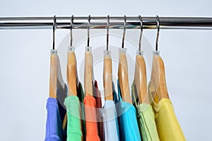 T-shirts of different colors hang on closing rack