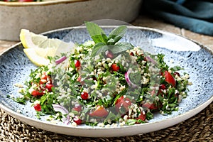 Tabbouleh salad onion tomato and parsley in ceramic dish photo