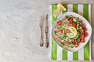 Tabbouleh Tabouli salad on a dish on light gray concrete background