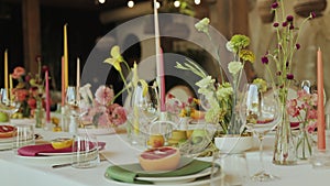 Table adorned with plates, candles, flowers, and fruit for a beautiful event