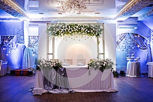 The table with arches and blue light is decorated in the hall photo