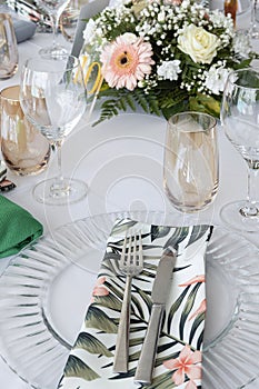 Table arrangement prepared for a formal event, a wedding or a special occasion, decorated with tropical-themed details