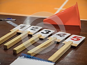 Table of a basketball game with the number of fouls, notebook, cone, scoreboard