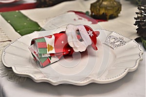 On the table a beautiful plate with Santa`s napkin holder photo