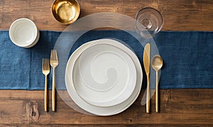 A table with a blue tablecloth and a white plate with a fork, knife