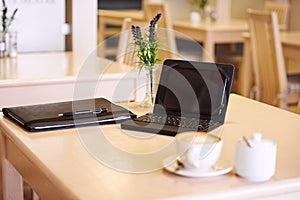 Table in a cafe with an electronic tablet and coffee