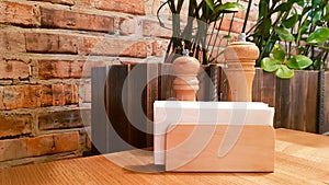 A table in a cafe or restaurant. White napkins in a wooden napkin holder, spices salt and pepper on a wooden table, panoramic view