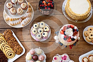 Table with cakes, cookies, cupcakes, tarts and cakepops.