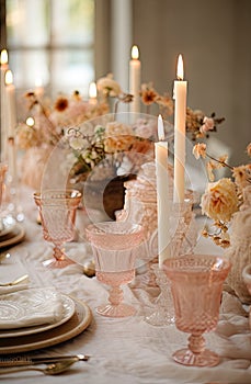 a table with candles and glasses and flowers