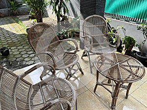 Table and chair made from rattan outside a house.