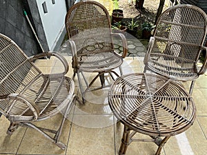 Table and chair made from rattan outside a house.