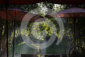 table and chair and red umbrella at patio with light ray through