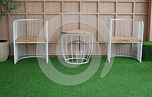 Table and chair set on green floor and wood background.